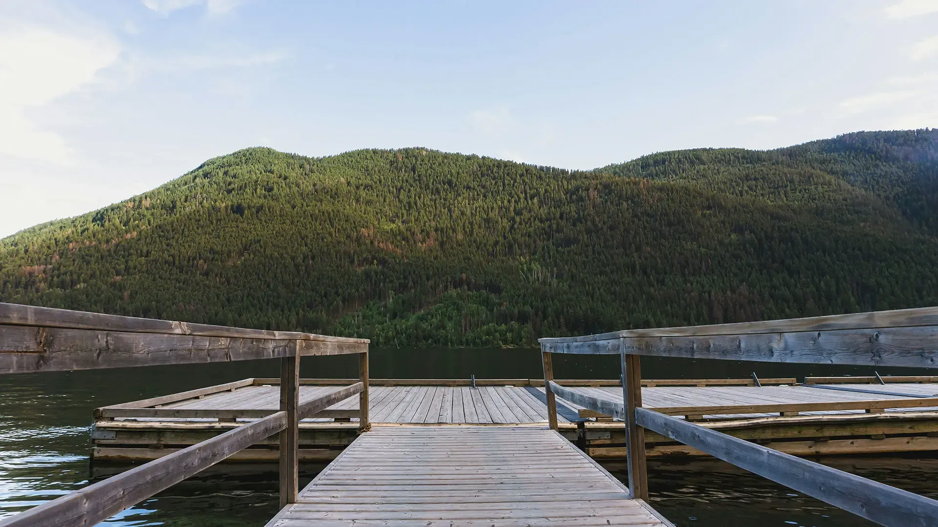 A wooden dock stretches out over calm water, inviting visitors to enjoy the serene lakeside view.