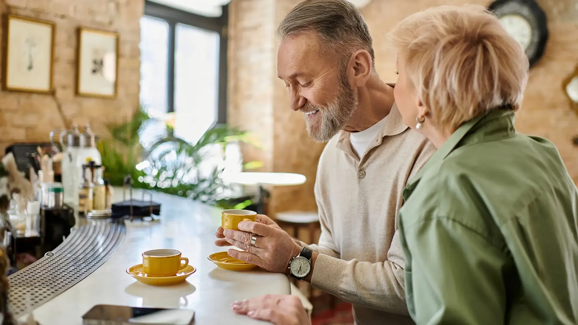 A man and woman sit at a bar, enjoying coffee together in a relaxed atmosphere.